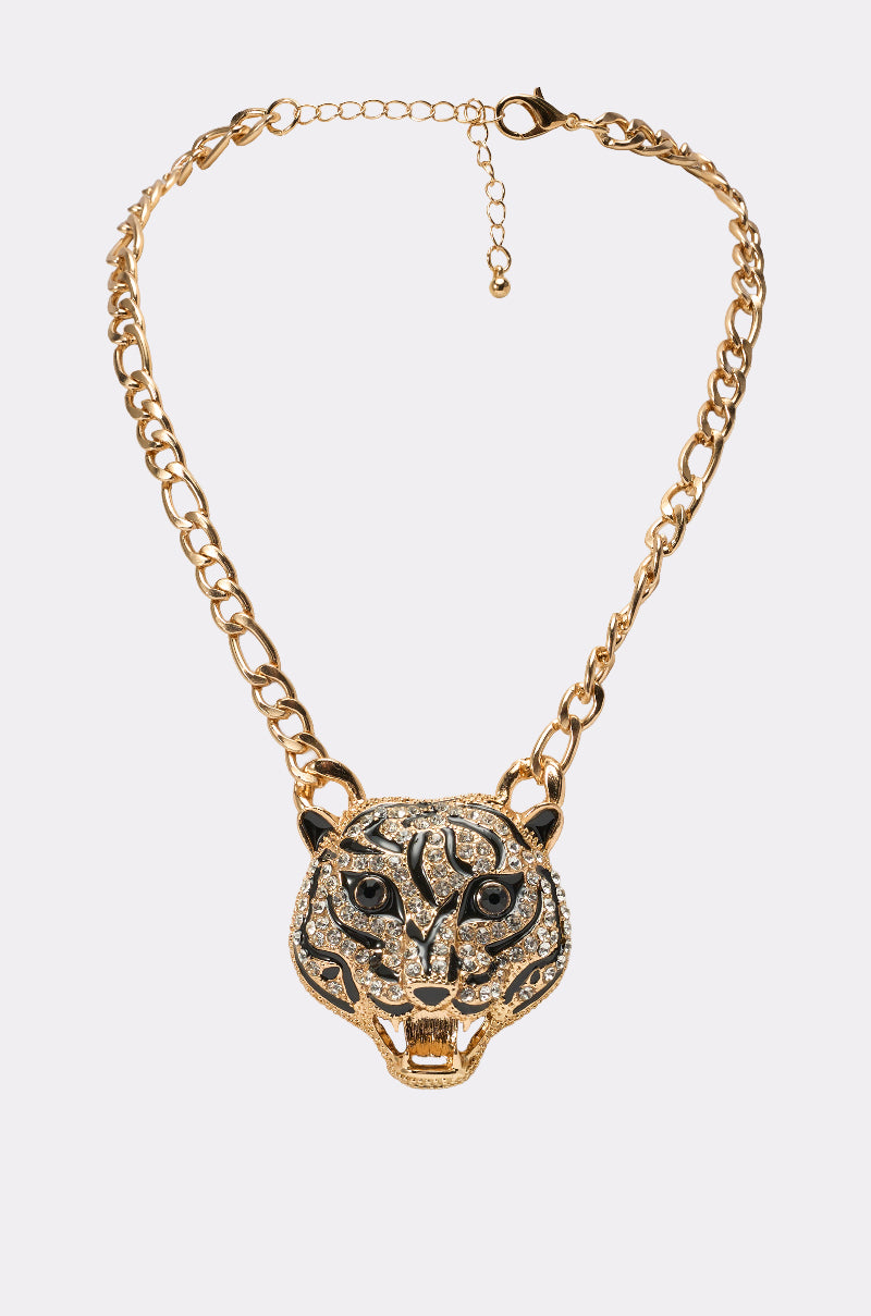 The HEAR ME NECKLACE features gold tone chain jewelry with a rhinestone tiger pendant, adorned with sparkling stones and black detailing on the eyes, nose, and stripes, shown against a plain light background. 0