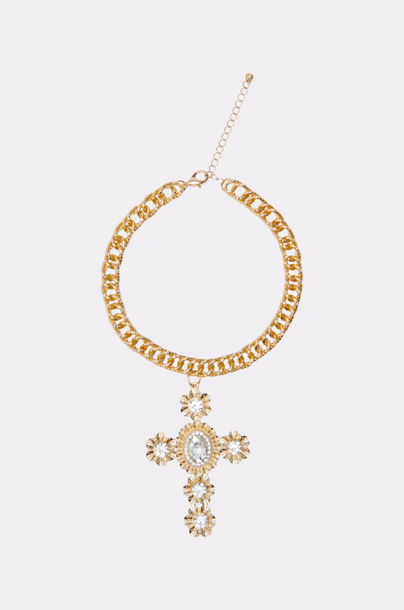 The KIMMY NECKLACE showcases a gold chain with an adjustable clasp and a large cross pendant, decorated with floral rhinestone accents for added sparkle. 0