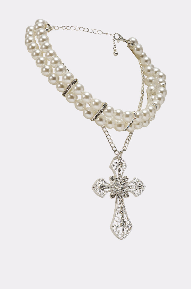 The PURE CROSS NECKLACE is a double-stranded pearl choker with silver accents, showcasing an ornate rhinestone cross pendant with intricate details, displayed on a white background. 2