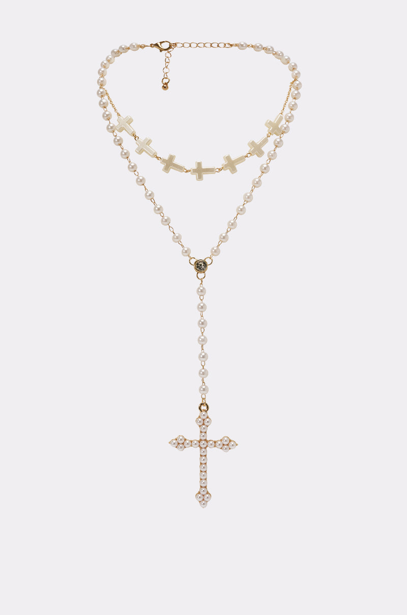 The IN YOUR DREAMS NECKLACE features a vintage-inspired layered pearl design with small white beads, multiple gold crosses, and an adjustable lobster clasp, beautifully displayed on a plain light background. 1