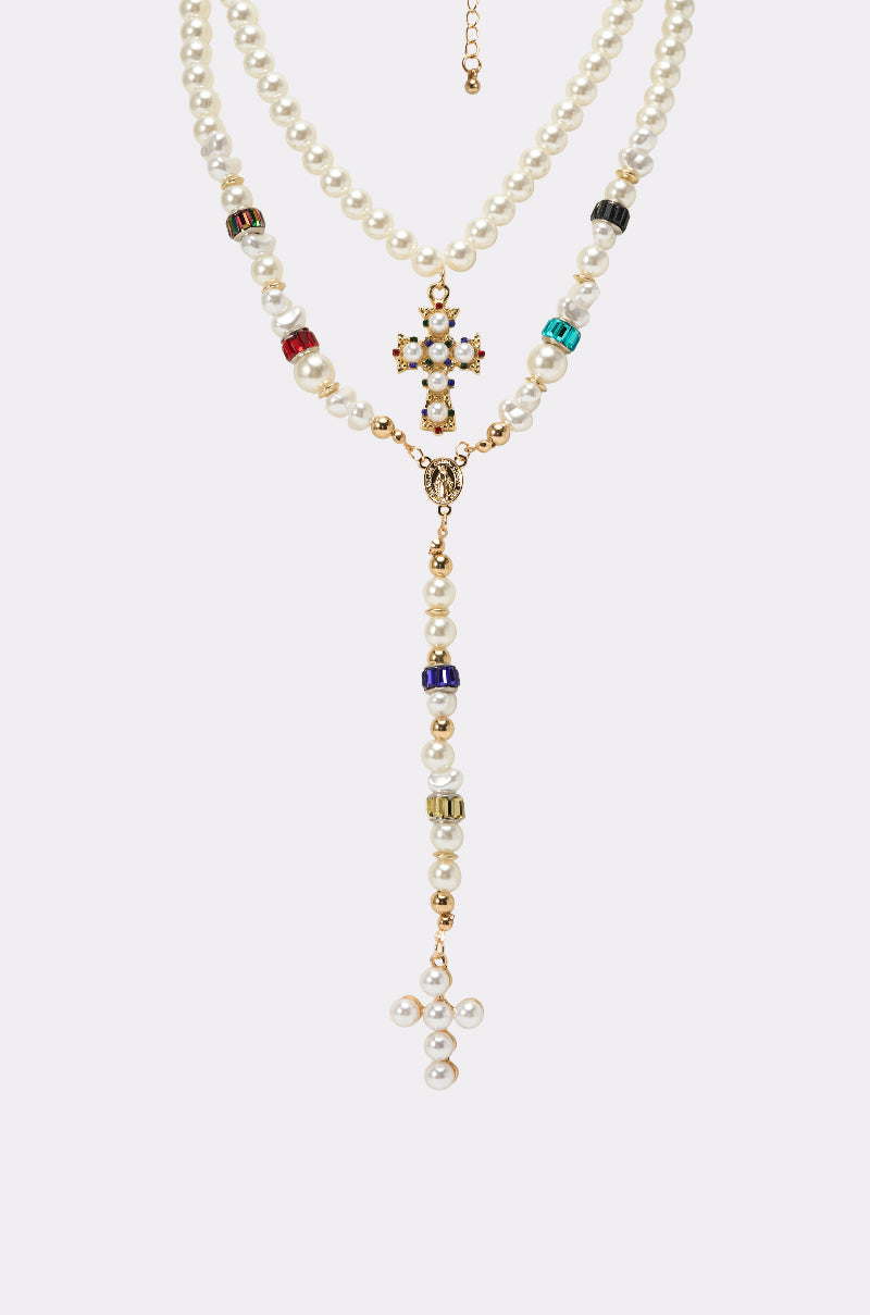 The ON BISCAYNE NECKLACE is a double-strand pearl necklace set with gold accents, colorful gemstones, and two cross pendants—one with pearls and gems, the other with pearls—shown on a plain light background. 2