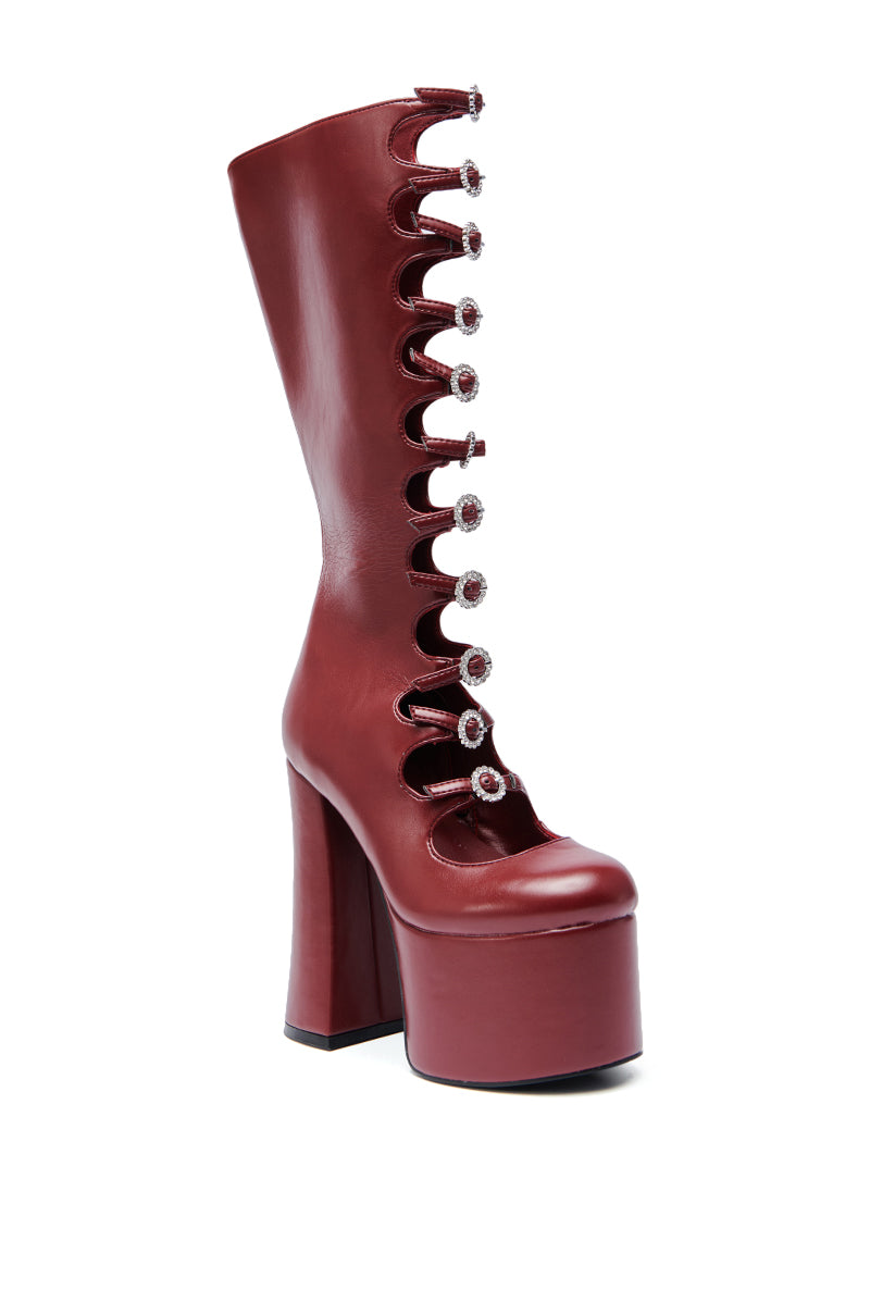 The AZALEA WANG TOMLIN BURGUNDY PLATFORM BOOT features glossy faux leather, a chunky high heel, front cut-out, and central crystal button accents.