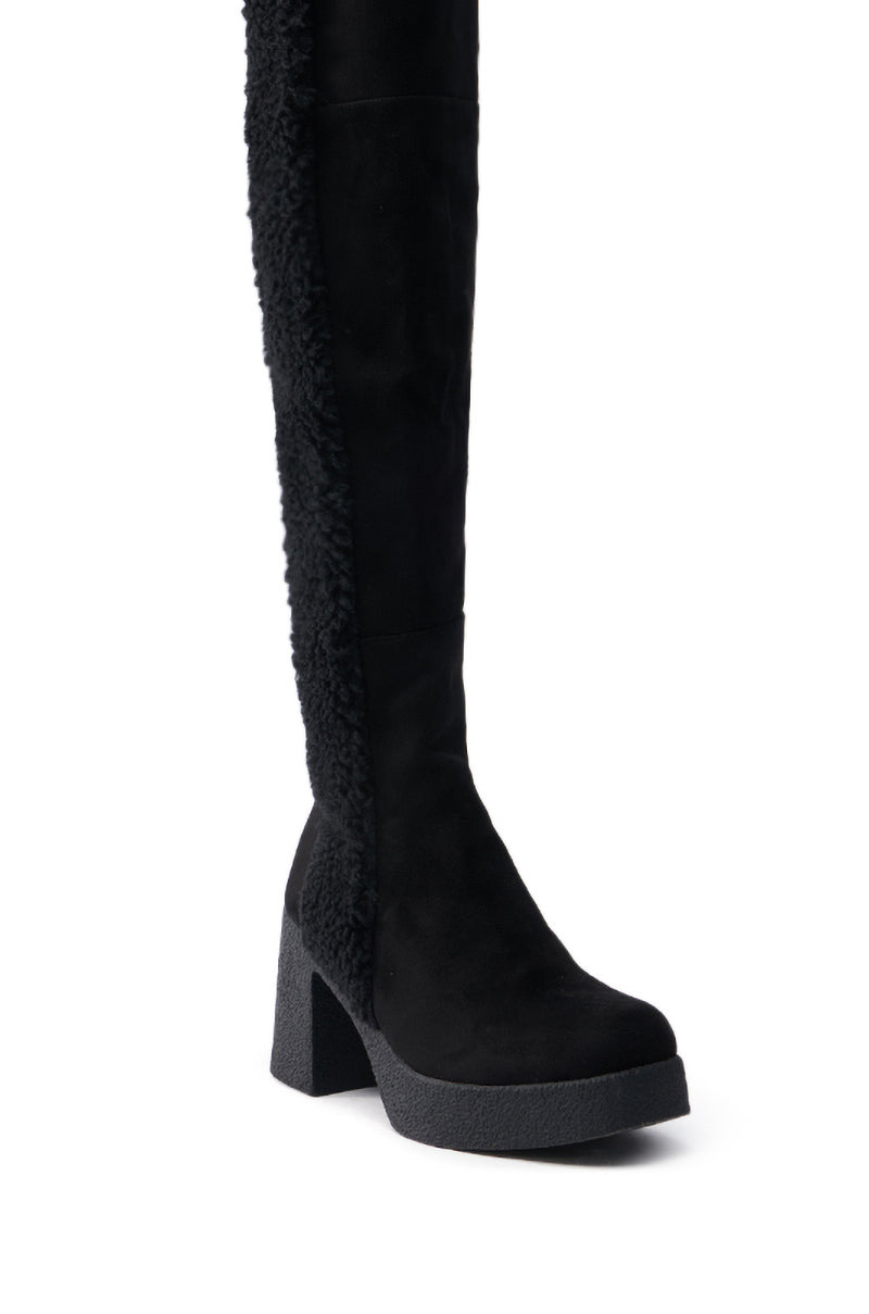 The TOP TIER BLACK CHUNKY BOOT is a knee-high boot featuring a textured faux suede side, thick block heel, smooth front and toe, and rugged sole, combining style with winter wear functionality.
