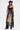 A woman poses against a white background, wearing the SEE YOU LATER LACE BLOUSE over a black bra, paired with a black cowboy hat, denim cutoff shorts, and black cowboy boots with silver chains.
