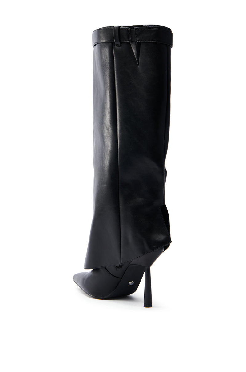 The AZALEA WANG TRACKSTAR BLACK STILETTO BOOT is an elegant black high-heeled boot with a pointed toe and unique fold-over design, featuring a strap and buckle. Its sleek and narrow heel enhances the fashionable silhouette against a plain white background.