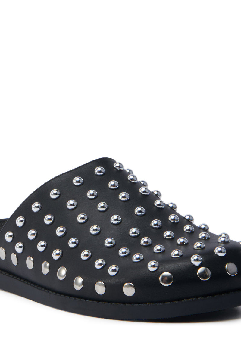 The AZALEA WANG TRAVERSE BLACK CLOG is crafted from faux leather, featuring silver studs across the top and side for a bold look. Its flat sole offers comfort, while its angled design highlights its striking style.