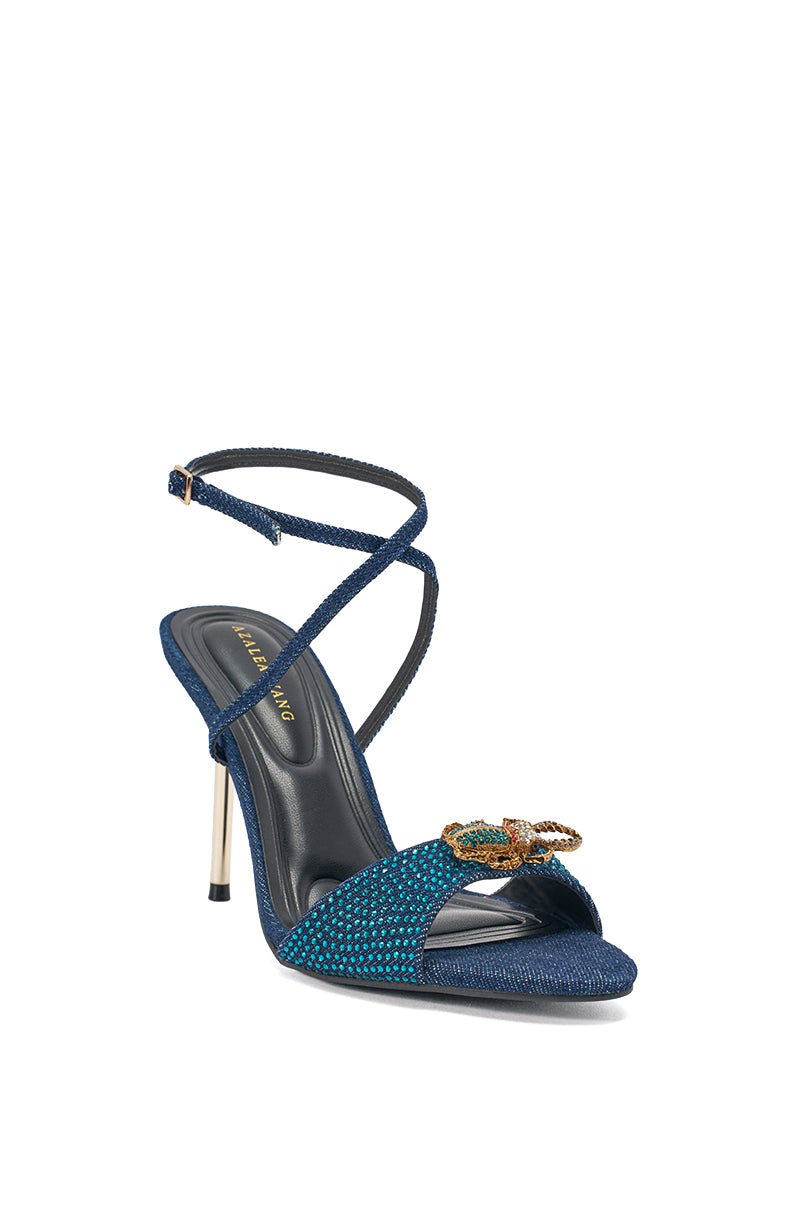 The AZALEA WANG TREETOK DENIM RHINESTONE STILETTO SANDAL features a blue textured finish, crystal embellishments, crisscross ankle straps, and a gold butterfly detail on the toe strap. 3