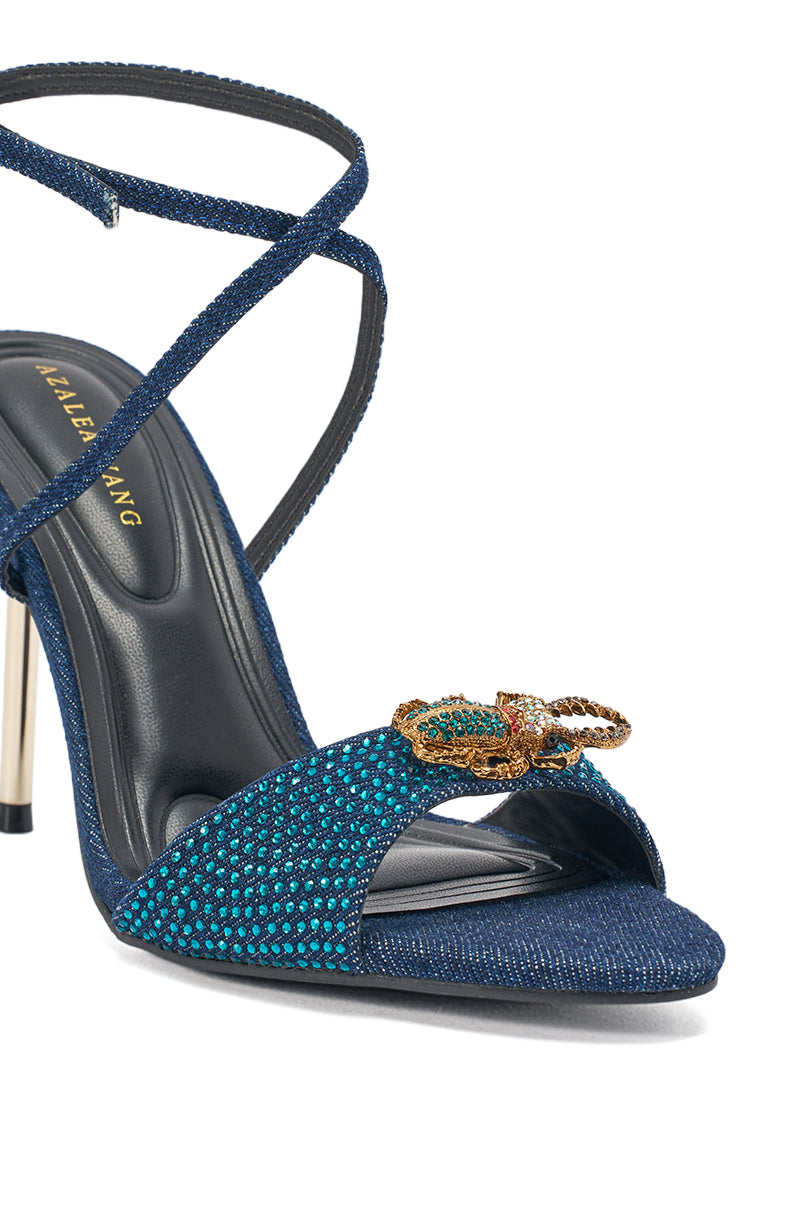 The AZALEA WANG TREETOK DENIM RHINESTONE STILETTO SANDAL showcases blue denim, crisscross ankle straps, a jeweled snake on the toe strap, sparkling teal and blue rhinestones, and a slim metallic heel. 5