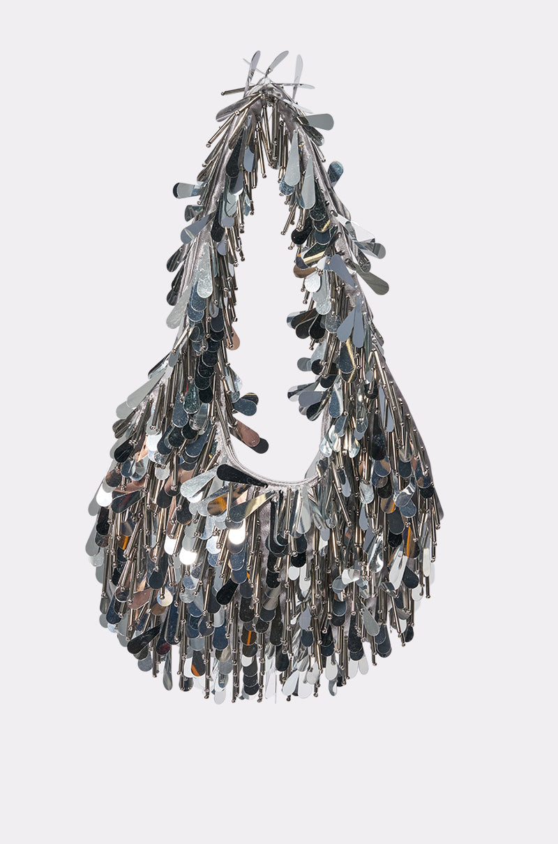 The SHAKE IT SILVER FESTIVAL BAG features layered, shiny metallic sequins for a textured, glamorous style. With its rounded shape and single shoulder strap, it’s ideal as a concert purse or for a girls’ night out.
