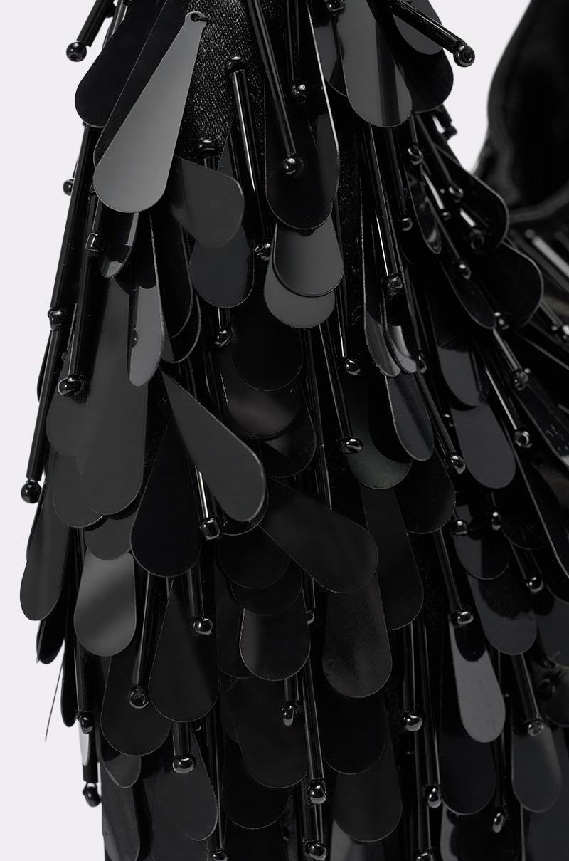 Close-up of overlapping black teardrop-shaped sequins and small beads, creating a textured, shiny, layered pattern on THE NOSTALGIA SEQUIN PURSE IN BLACK.