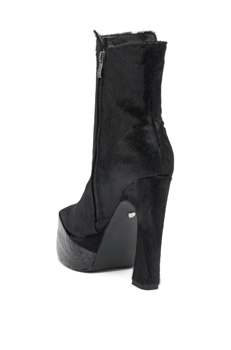 The AKIRA GOLD TROT BLACK BOOTIE is a high-heeled, black bootie with a platform toe, side zipper, chunky heel, and genuine calf hair textured finish.