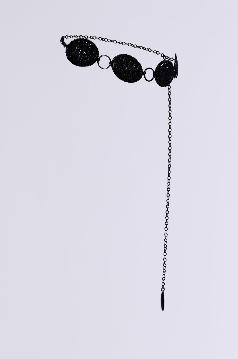 The CARTER BLING CHAIN BELT is a delicate, adjustable chain belt featuring round, mesh-like interconnected discs and rhinestone detailing. It includes a long dangling chain on one side and is set against a plain light background. 4