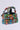 Introducing the I GO FAST RACE CAR PURSE, a handbag made from vibrant toy race cars, meticulously arranged in rows and layers for a playful structure. The handle is also crafted from toy cars, all set against a simple light background.