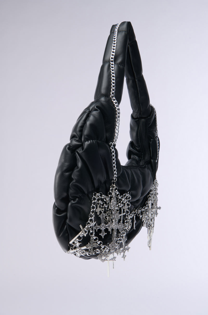 The TOO SPECIAL CROSS CHAIN PURSE is a black faux leather, padded crescent-shaped bag with gothic hardware and silver cross charms on the front, shown against a plain light gray background. 3