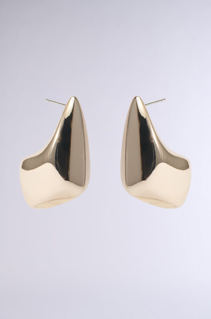 A pair of ZELLY STATEMENT EARRING in faux gold, showcasing an abstract, sculptural silhouette against a light gray background. These earrings feature a smooth, shiny finish with an asymmetrical design and come with posts for wearing. 0