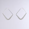 Introducing "THE BIGGER THE HOOP EARRING," a pair of silver geometric earrings with a modern design. These earrings feature a distinctive curved triangular shape, accented by subtle coil spring detailing, and boast a sleek and shiny finish. Displayed against a neutral light background, they capture attention with their stylish allure.