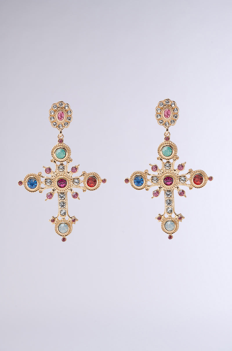 The YOUR MAJESTY EARRING features elegant faux gold cross-shaped design with multicolored rhinestones in blue, red, pink, and green. Detailed engraving and floral motifs enhance their ornate style against a neutral backdrop.