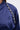 Close-up of the CALL BACK SATIN BOMBER in navy blue satin, showing its cropped silhouette and an eye-catching line of large rhinestone trim along the shoulder seam for added sparkle and elegance.