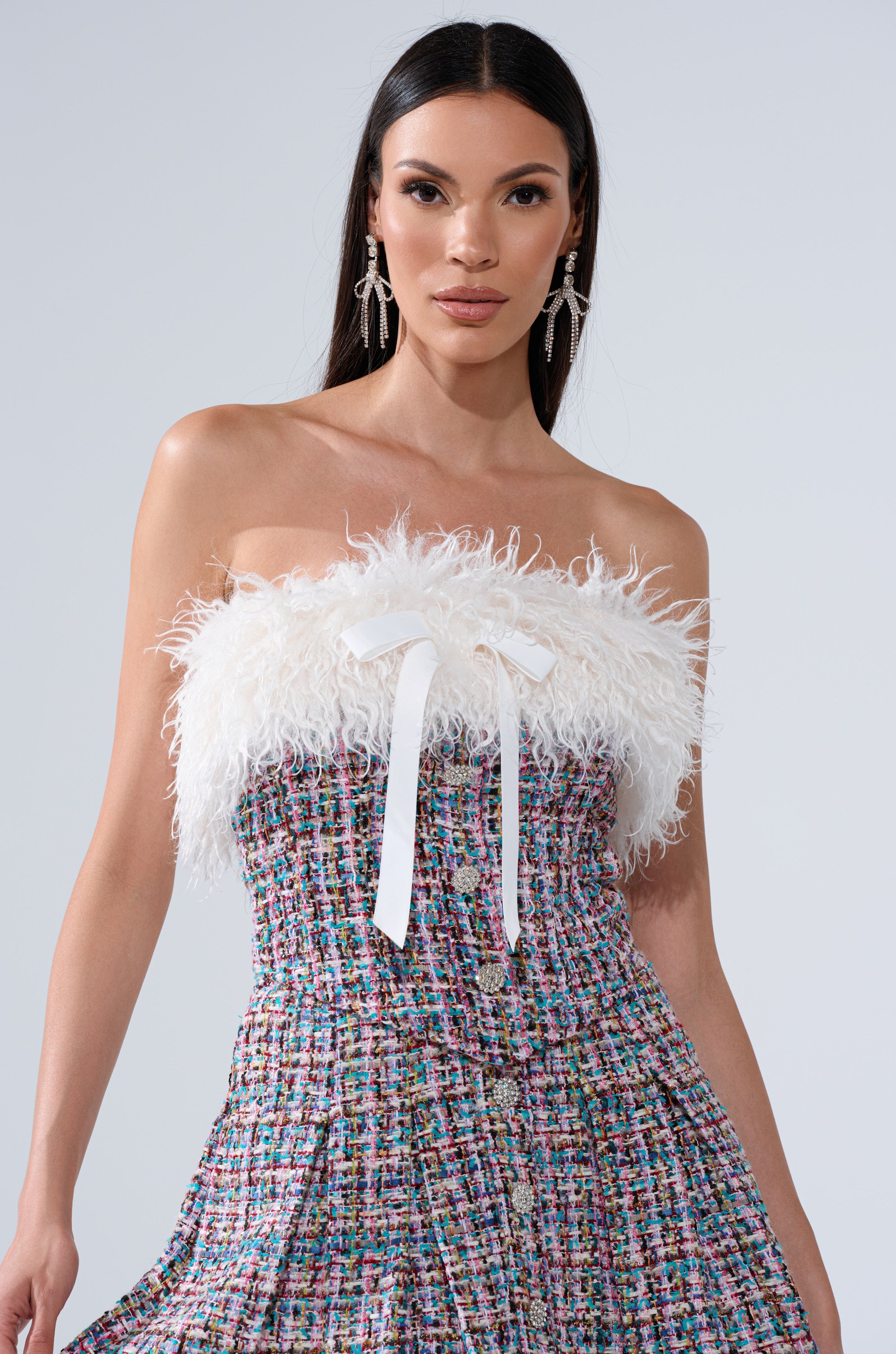 A woman in the FUR TRIM TWEED CORSET, featuring rhinestone-adorned buttons, radiates elegance and style.