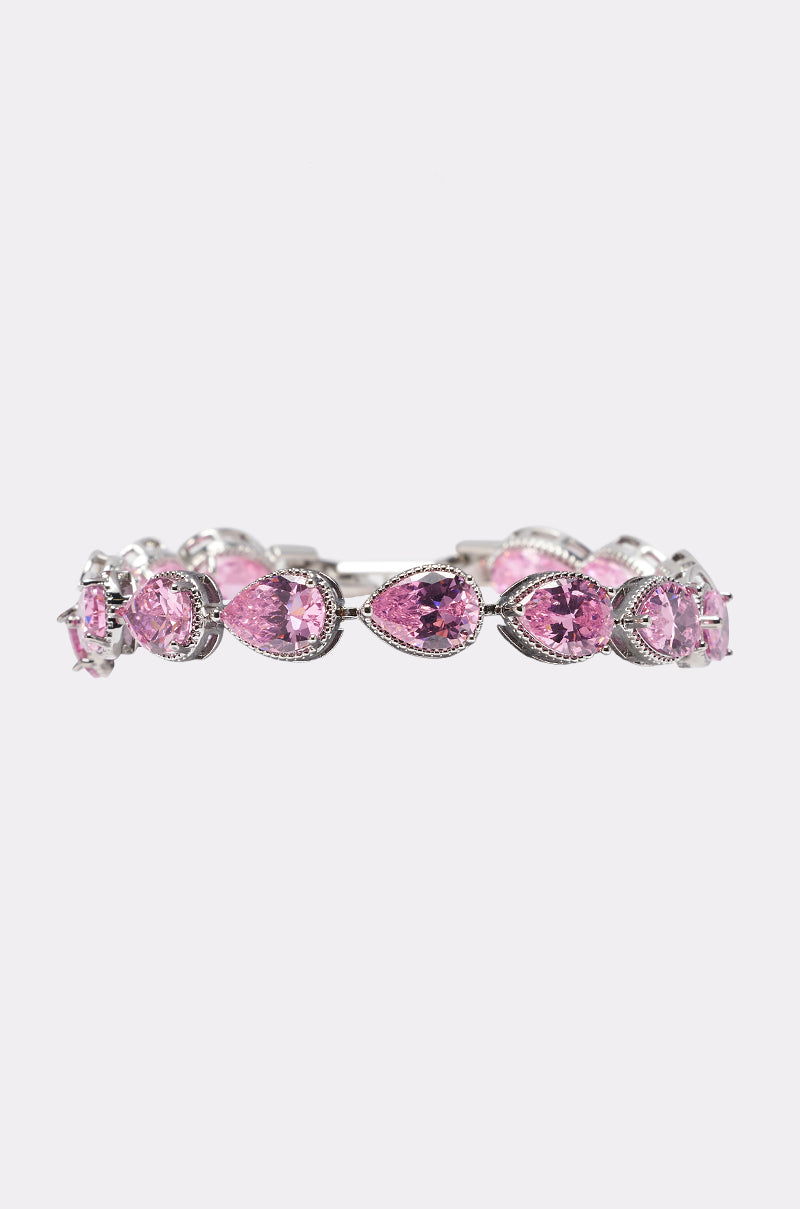 The GEORGINA BRACELET features alternating oval and teardrop-shaped pink cubic zirconia gemstones, each set in individual pronged settings on a sleek silver band. Displayed on a plain light gray background, this bracelet is an elegant choice for wedding guest jewelry.