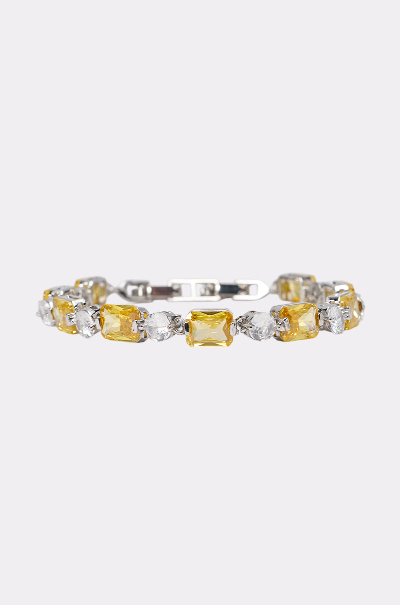 The CANARY BRACELET features alternating rectangular yellow rhinestones and oval clear stones, ideal as a stunning formal accessory for wedding guests. Pictured on a plain light background.
