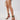 A person in frayed denim shorts and AZALEA WANG TZILLA MULTI COLOR ROPE STILETTO SANDALS holds a small white woven handbag while standing against a plain, light background.