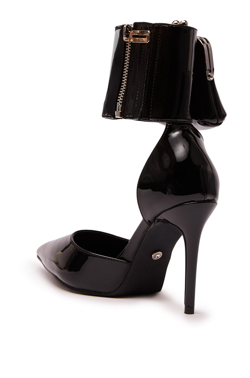 The AZALEA WANG TZIVA BLACK COIN PURSE PUMP features sleek faux patent leather, a pointed toe, stiletto heel, thick ankle cuff with zipper detail, and a unique coin purse accent—bold and sophisticated style.