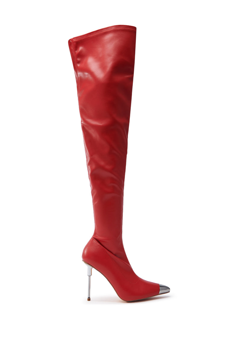 The UNA RED STILETTO BOOT is a strikingly modern and elegant single shoe, with a glossy faux leather finish, sharp metallic pointed toe, and sleek slim heel. Its captivating design features an eye-catching thigh-high silhouette.