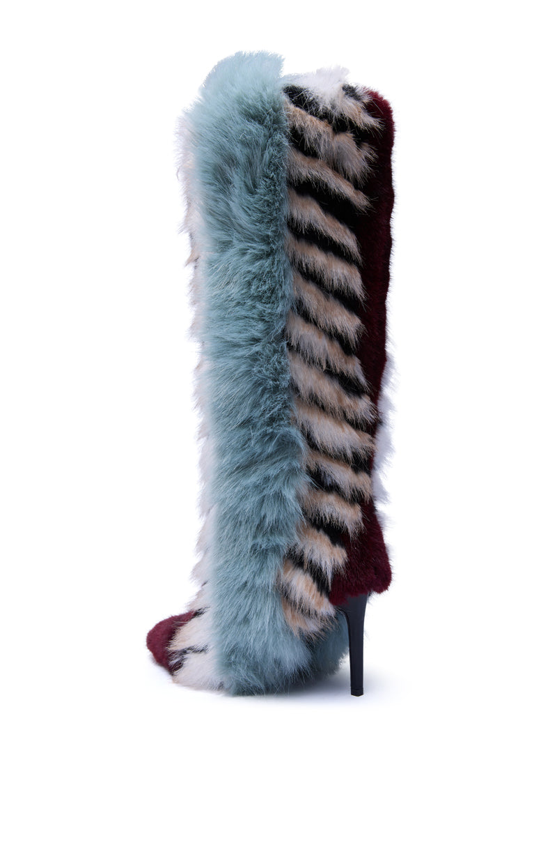 The AZALEA WANG UPSELLA BLUE MULTI STILETTO BOOT is a knee-high, high-heeled boot featuring fluffy faux fur in light blue, burgundy, white, and striped beige and black panels set against a white background.