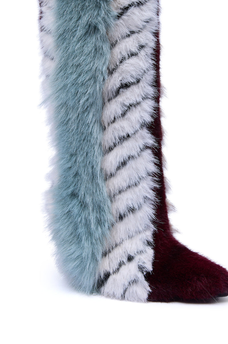 A close-up of the AZALEA WANG UPSELLA BLUE MULTI STILETTO BOOT: faux fur knee-high boots with three sections—light blue, white with black stripes, and dark burgundy fur on the toe and right side.
