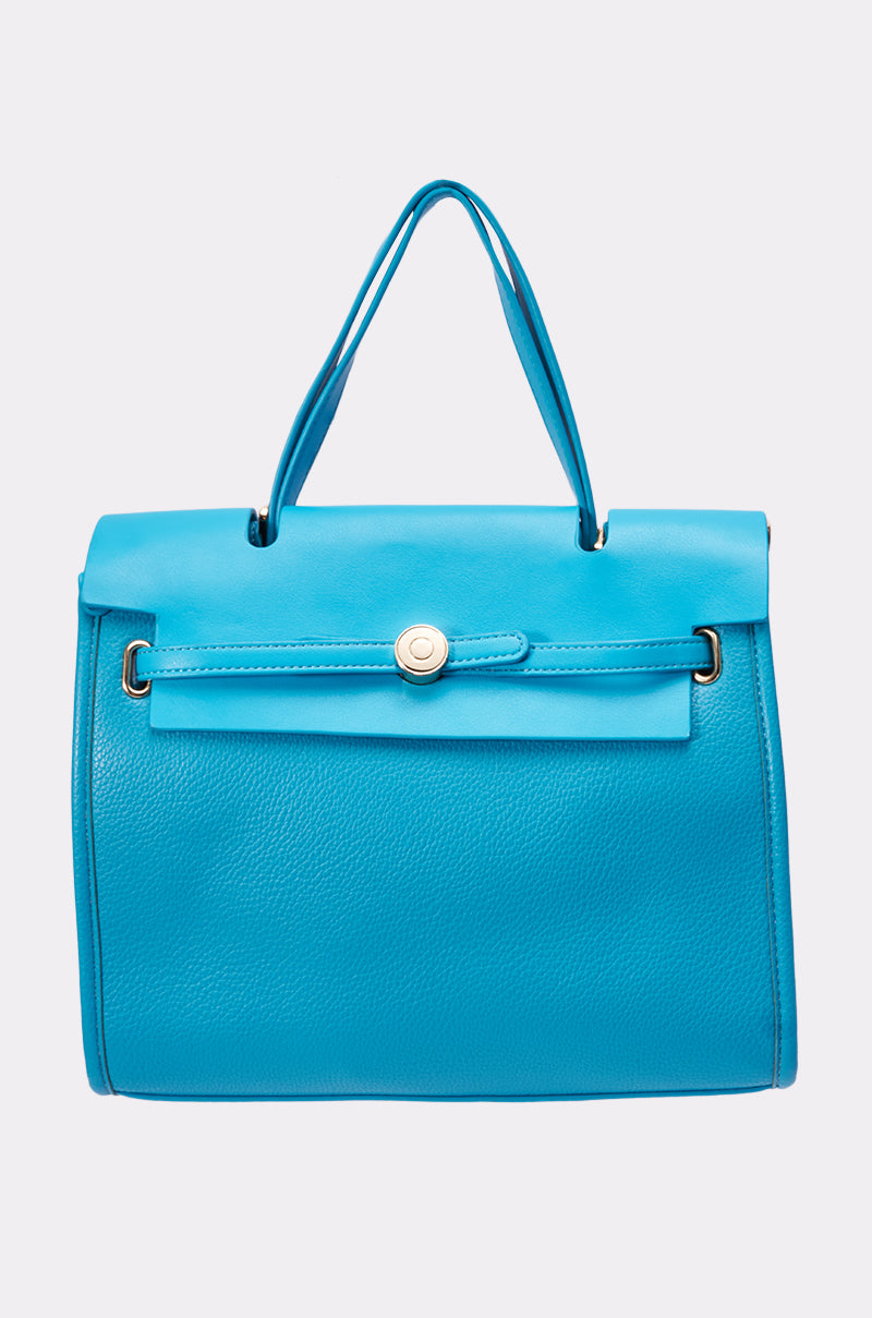 The TAKE ME OUT TOTE is a bright blue leather statement bag featuring a top handle, flap closure, gold button detail, and an optional crossbody strap for versatile styling. Pictured against a light gray background. 0