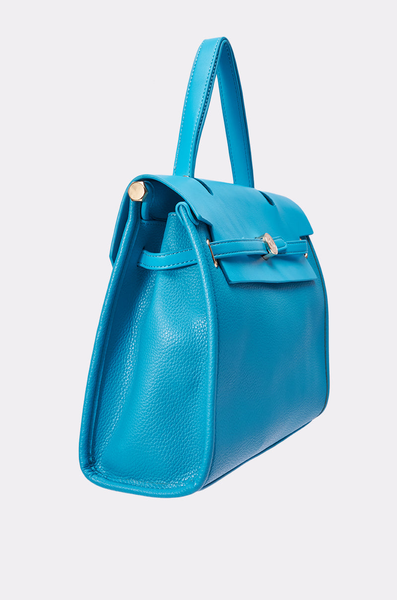 The TAKE ME OUT TOTE is a bright blue structured leather bag with a top handle and gold hardware, featured at a three-quarter angle against a plain light background. 2