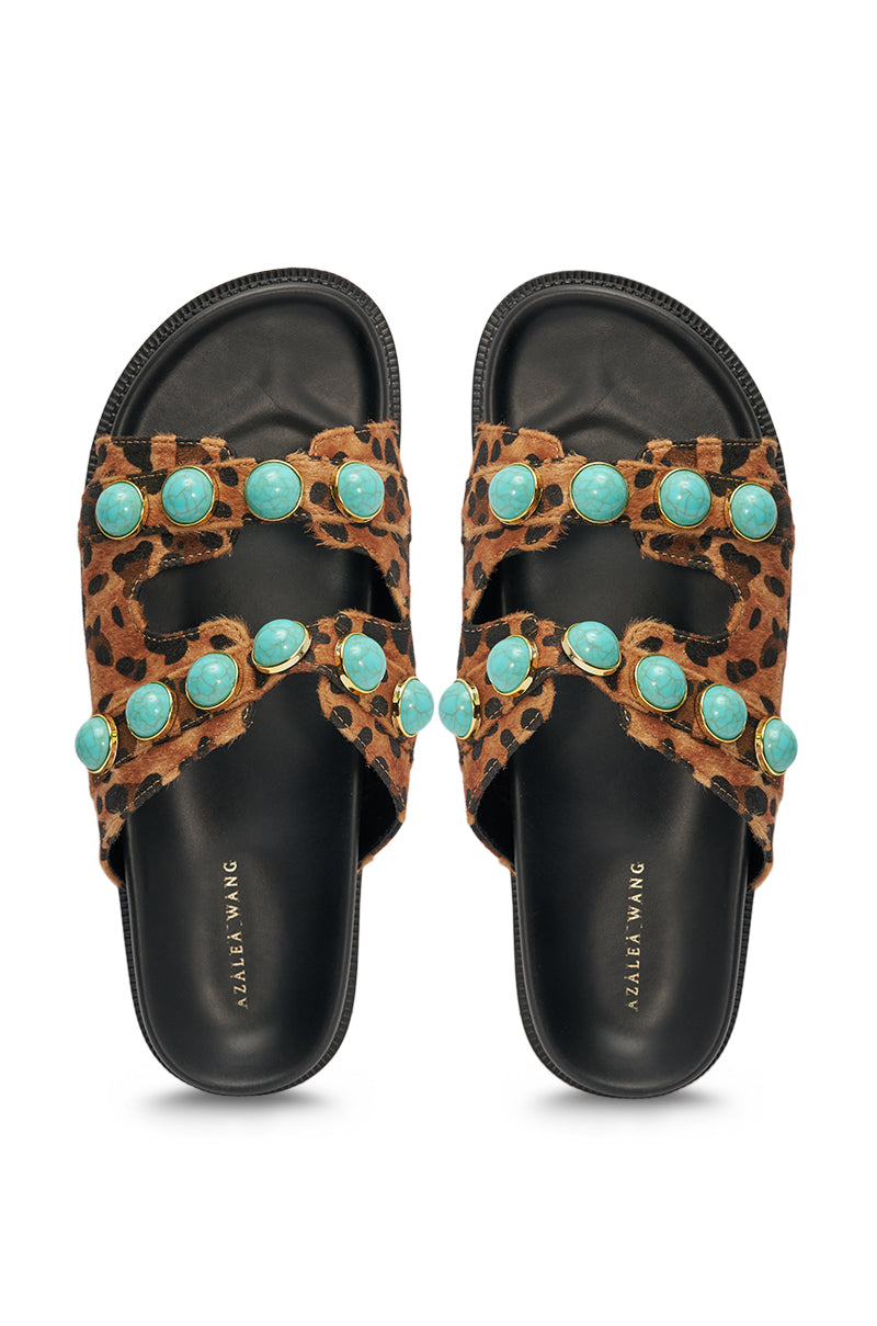 The AZALEA WANG UZUMATI Leopard Slip On Sandal With Stones features western-inspired leopard print straps adorned with large turquoise stones, plus black soles with "ALEXIA WANG" in gold on the footbeds. 3
