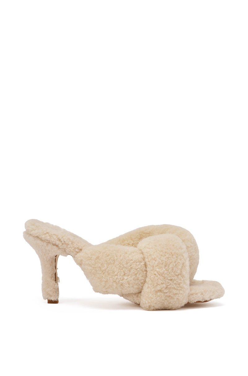 The AZALEA WANG VALE IVORY SHERPA LOW HEEL MULE SANDAL features a cream-colored faux sherpa texture, plush crisscross straps, an open toe, and a short heel for a cozy-chic look. 3