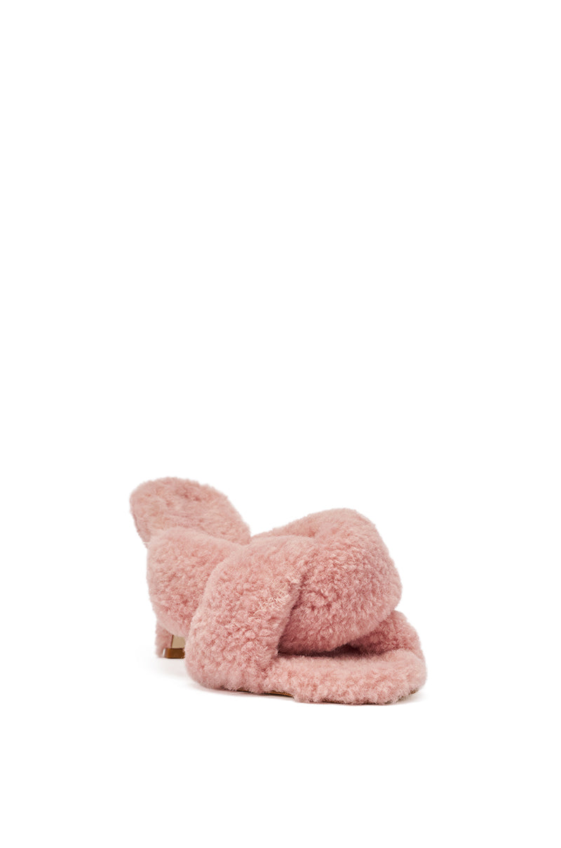 The AZALEA WANG PINK VALE IVORY SHERPA LOW HEEL MULE SANDAL is a pink mule with crisscross straps, crafted from soft sherpa material, shown singly against a plain white background. 4