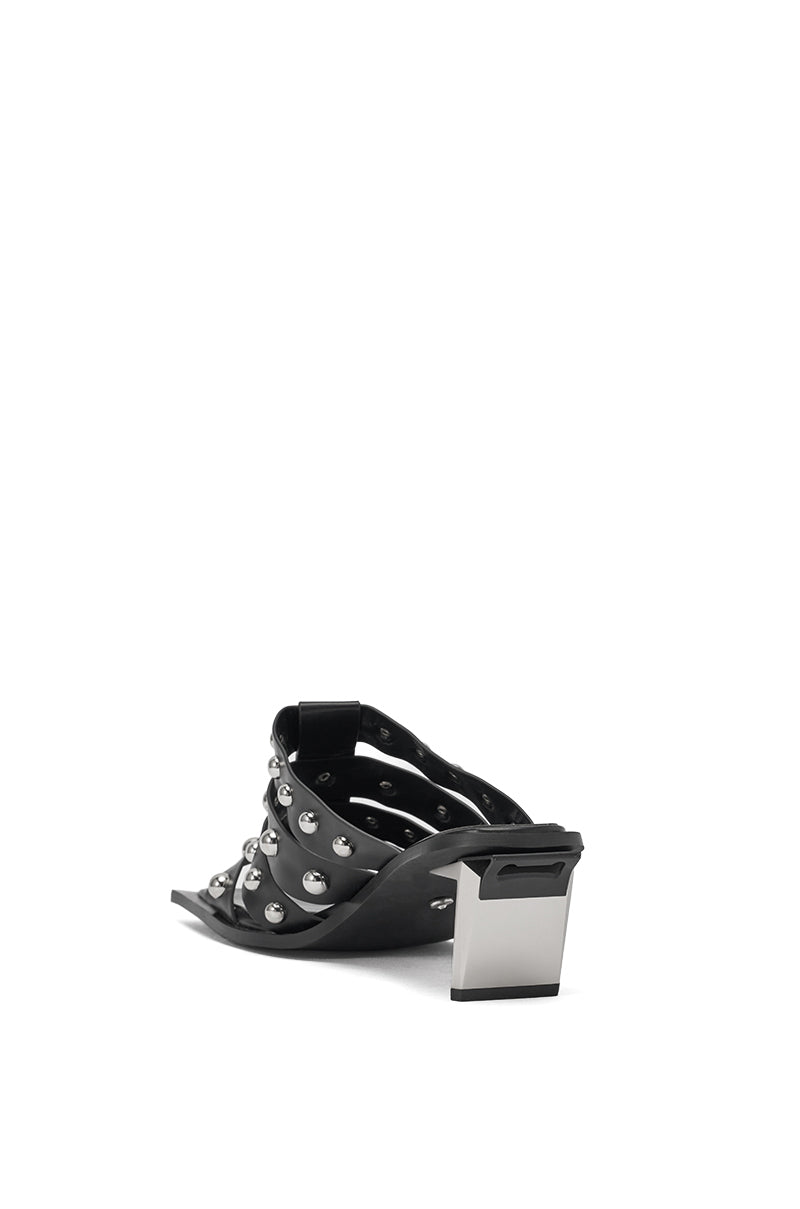 The AZALEA WANG VANDAL BLACK NOVELTY HEEL SANDAL features black faux leather, silver studs, and a chunky metallic block heel, displayed from the back against a plain white background. 6
