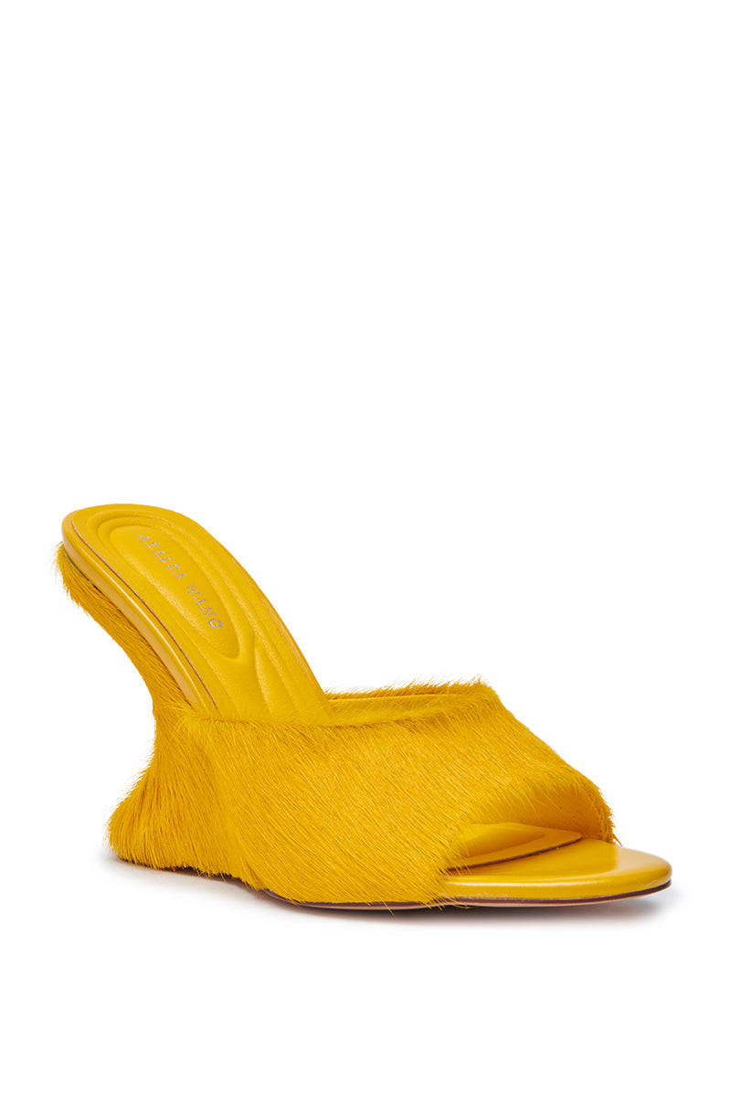 The AZALEA WANG VASA MUSTARD OPEN TOE SANDAL features a bright yellow hue, high heel, and unique textured faux fur covering both the upper and heel.