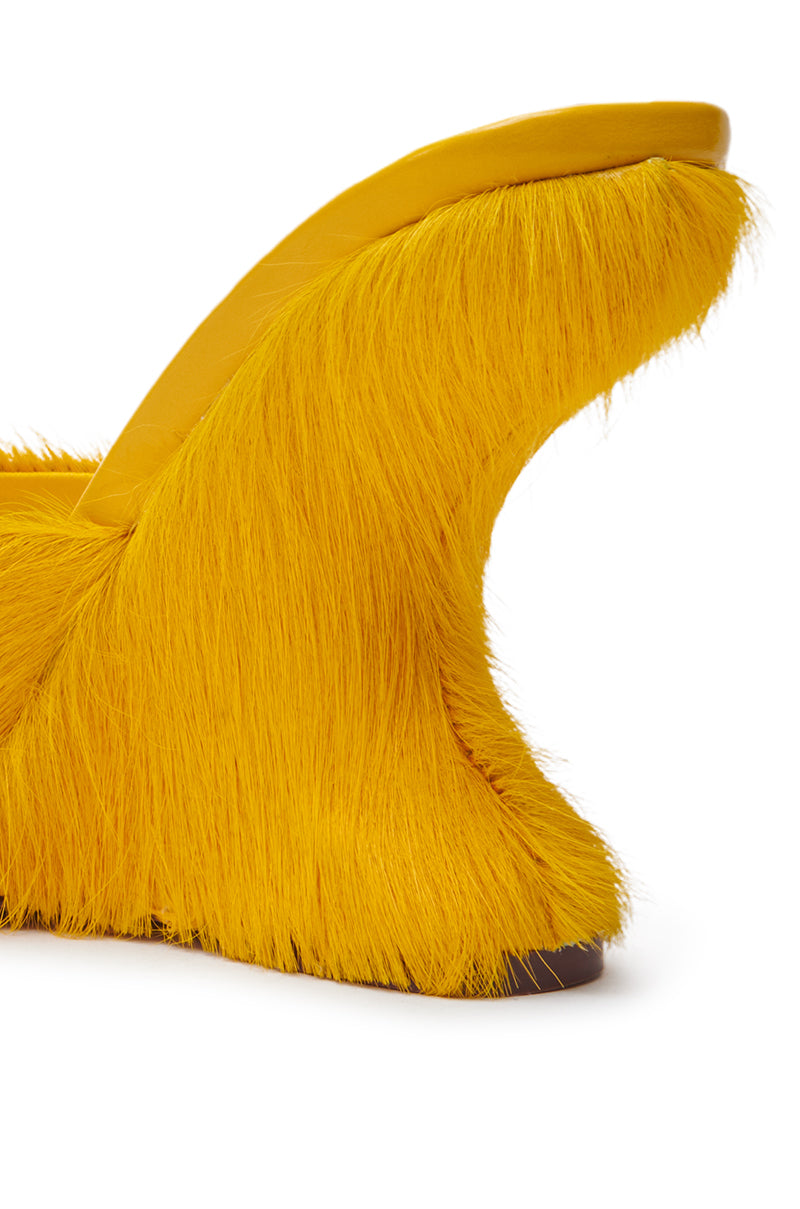 A close-up of the AZALEA WANG VASA MUSTARD OPEN TOE SANDAL, featuring a bold, modern look with a high bright yellow faux fur heel and an open toe design showing the heel and part of the footbed.