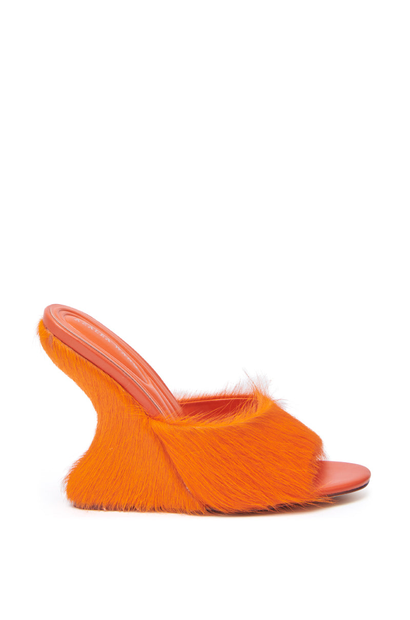 The AZALEA WANG VASA ORANGE FURRY WEDGE SANDAL features a high, sculpted wedge heel, bright orange faux fur, and an open almond toe, shown on a plain white background. 4