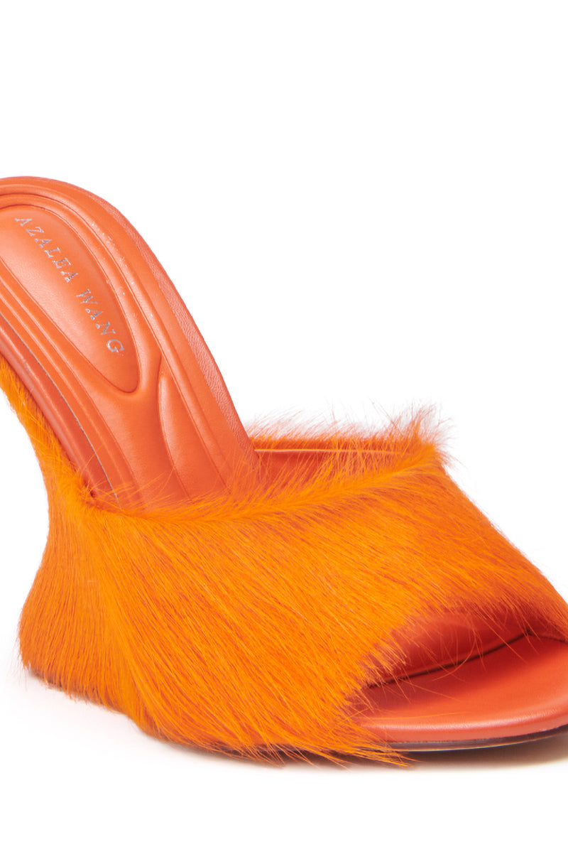 The AZALEA WANG VASA ORANGE FURRY WEDGE SANDAL features bright orange faux fur, a pointed toe, cushioned insole with embossed branding, and luxe faux pony hair for added texture. 7