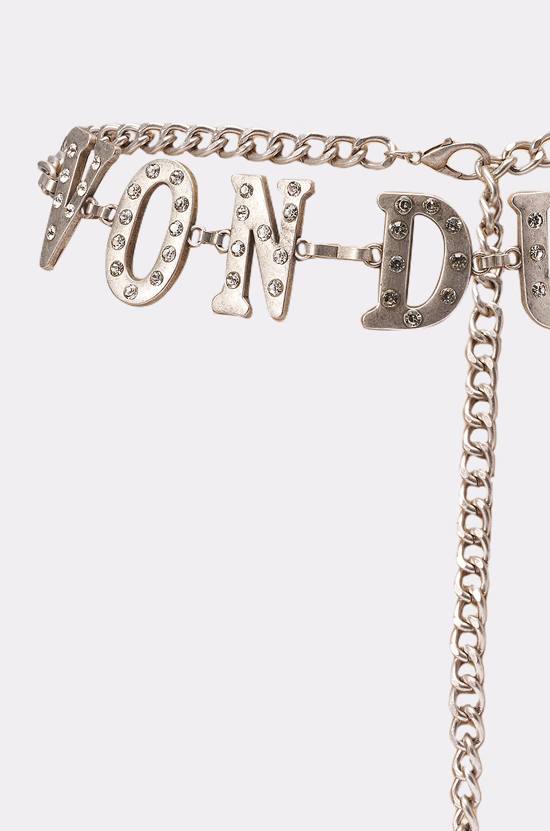 The VON DUTCH RHINESTONE CHAIN BELT features large, sparkling rhinestone letters on a silver chain—an eye-catching accessory that stands out against a plain white background. 2