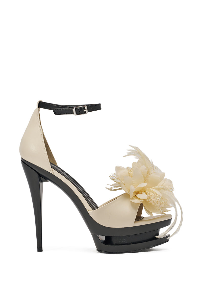 The AZALEA WANG VELVETINE IVORY STILETTO PLATFORM SANDAL features an ivory faux leather design with a black ankle strap and light yellow flower and feather embellishments on the front. 3
