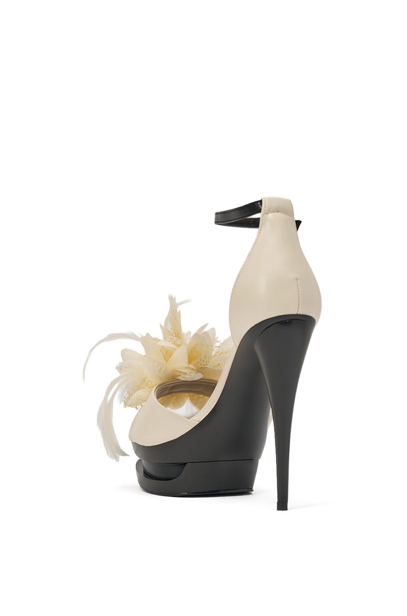 The AZALEA WANG VELVETINE IVORY STILETTO PLATFORM SANDAL features a cream faux leather upper, black platform and heel, ankle strap, plus yellow and white feather details. Shown from the rear against a white background. 5