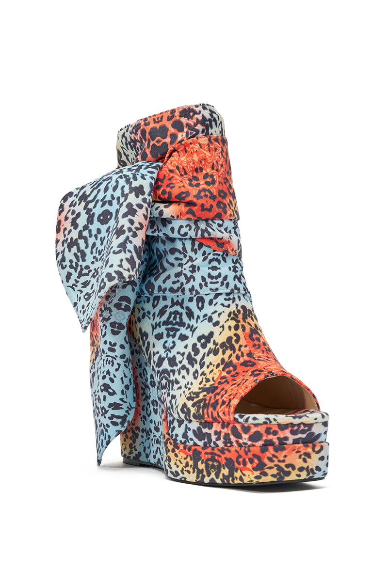The AKIRA GOLD VENEZIO MULTI COLOR CHEETAH PRINT WEDGE BOOTIE features bold platform heels, a vibrant cheetah print, an oversized side bow, and an open toe—making it a standout Y2K-inspired statement piece. 5