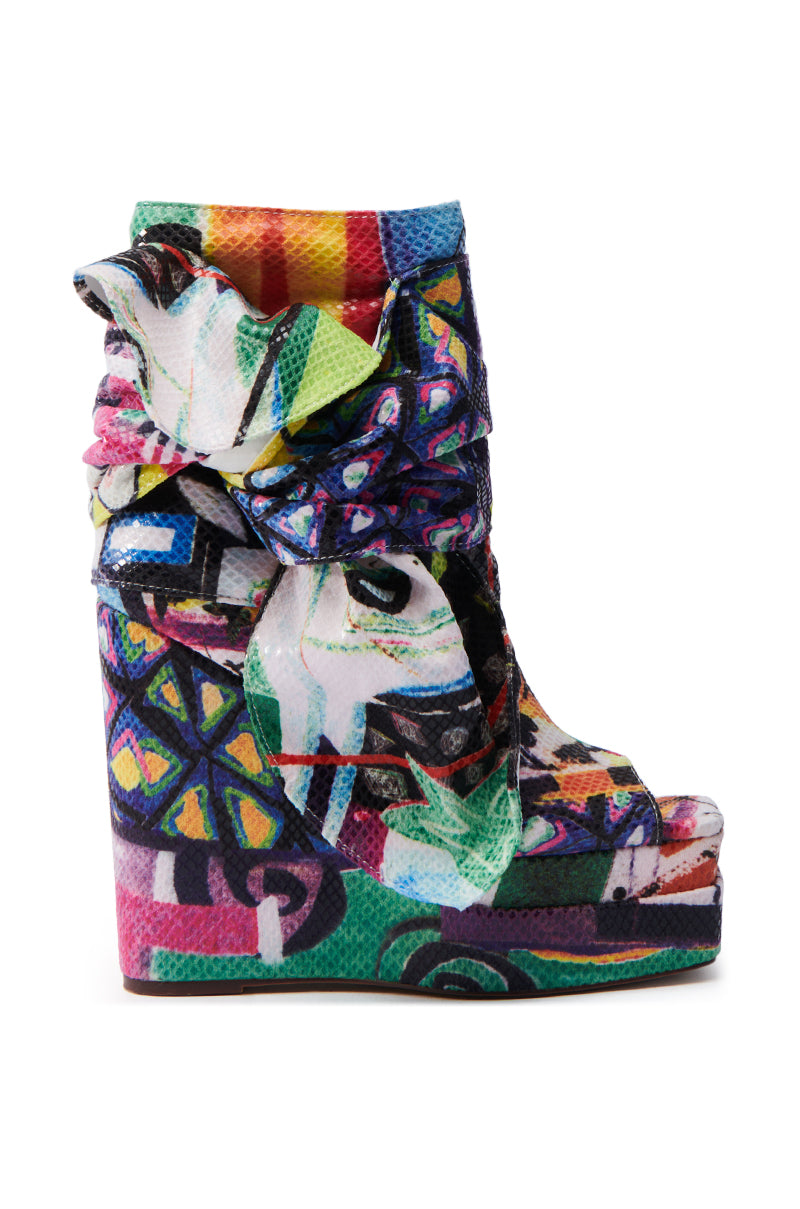 The AZALEA WANG VENEZIO MULTI BOOTIE is a colorful wedge heel shoe with a vibrant abstract technicolor print, textured surface, bold artistic design, peep-toe, and ruffled top—truly a neon dream.