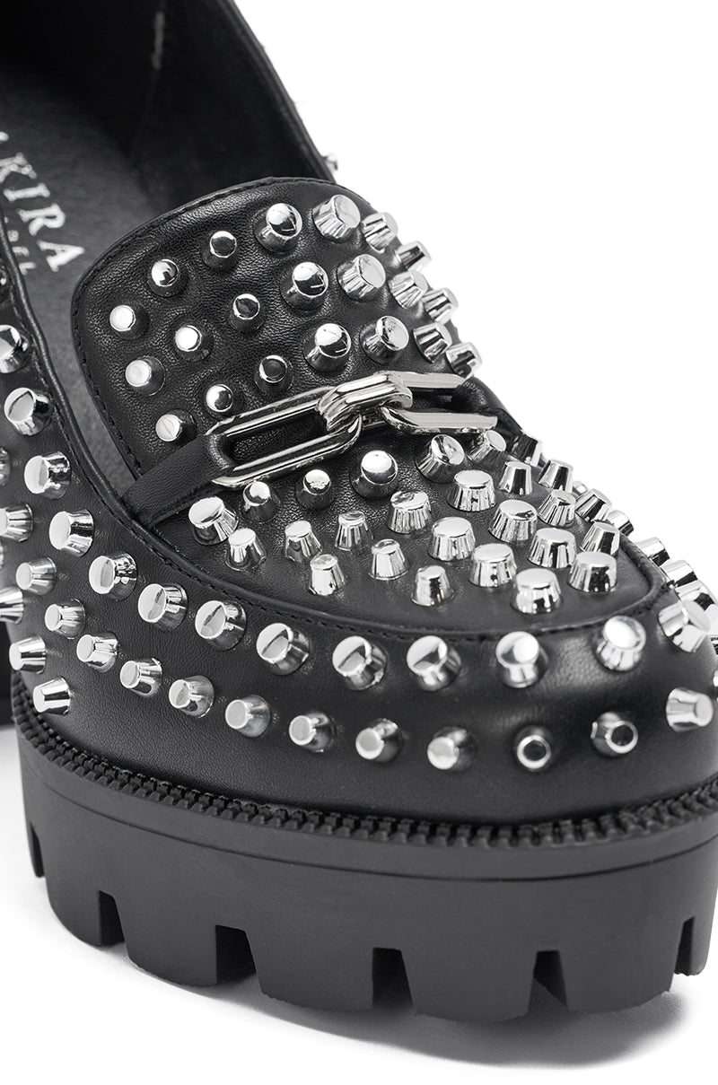 Close-up of the AKIRA GOLD VICTOIRE BLACK STUDDED PUMP LOAFER, a black loafer with a chunky platform lug sole and decorated with assorted silver metal studs. 6