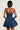 A person is seen from the back wearing the BELLA LOO navy mini dress, which features a strapless neckline and a voluminous, balloon-shaped skirt. Their short, straight hair contrasts against a plain light background.