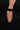 Close-up of a person wearing the DANCING QUEEN BEADED MINI DRESS, a black mini dress with a deep V-neckline, midriff cutout, and shimmering sequin embellishments throughout.