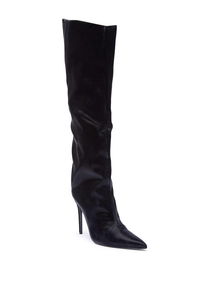 The AZALEA WANG VIETTA BLACK LIQUID LUXE STILETTO BOOT features a tall, sleek pointed toe design with a slightly slouched shaft and faux leather finish, shown in striking black on a white background.