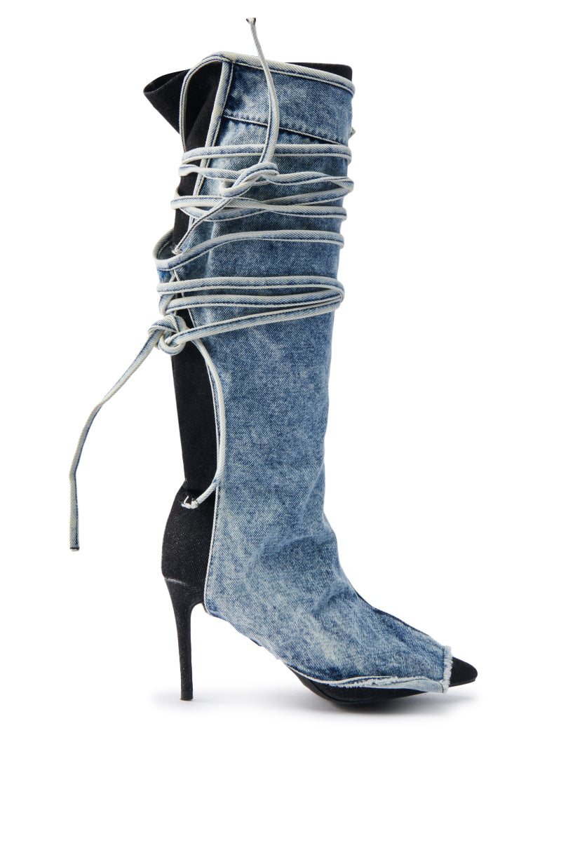 The AZALEA WANG VILLAREAL DENIM BOOT WITH TIES impresses with its knee-high shaft, peep toe design, and delicate light-colored strings wrapping around the ankle and calf. The slender stiletto heel adds chic style to this elegant high-heeled boot.